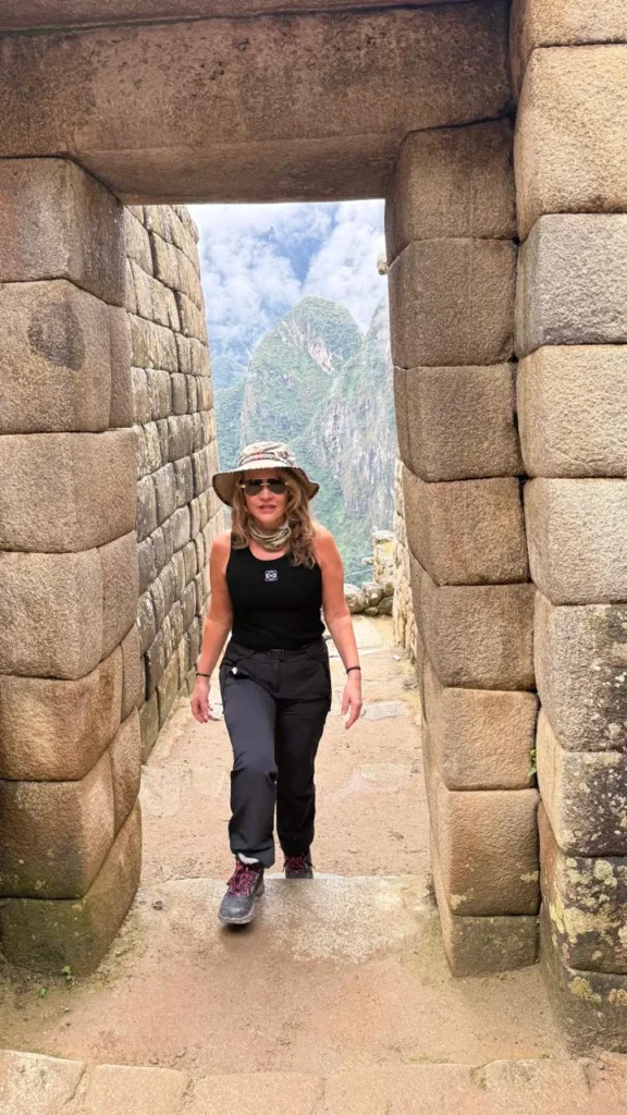 Viajante da Monde Travel caminhando por uma passagem de pedra em Machu Picchu