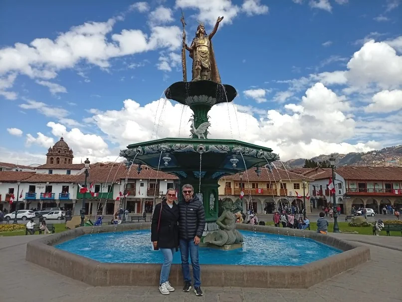 Casal de viajantes da Monde Travel diante da fonte do Inca Pachacútec na Plaza de Armas de Cusco