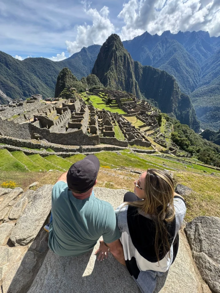 Casal contemplando a cidadela de Machu Picchu e as montanhas dos Andes, no Peru.