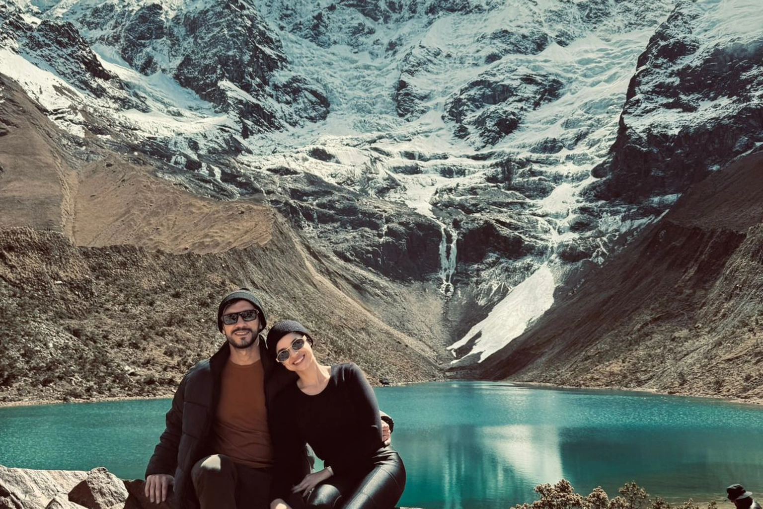 Casal contemplando a Laguna Humantay com montanhas nevadas ao fundo durante roteiro para Machu Picchu no Peru