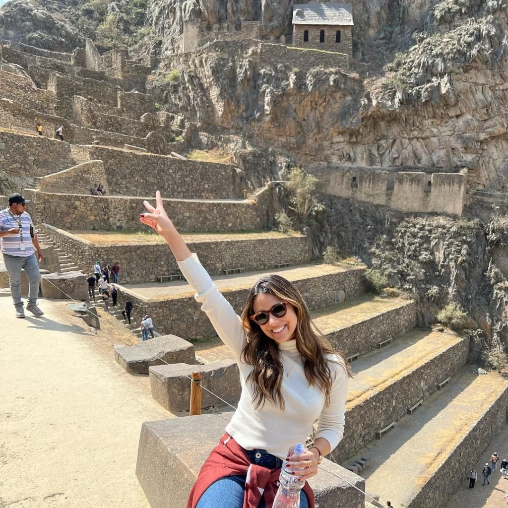 Viajante contemplando Ollantaytambo e as montanhas do Vale Sagrado dos Incas, no Peru.